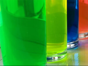 glass beakers with colourful liquids inside them. green blue and red liquids