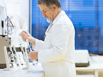 researcher carrying out scientific research in a lab using a gas chromatograph