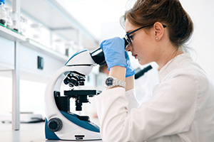 Biologist looking through microscope