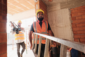 construction workers carrying ladders