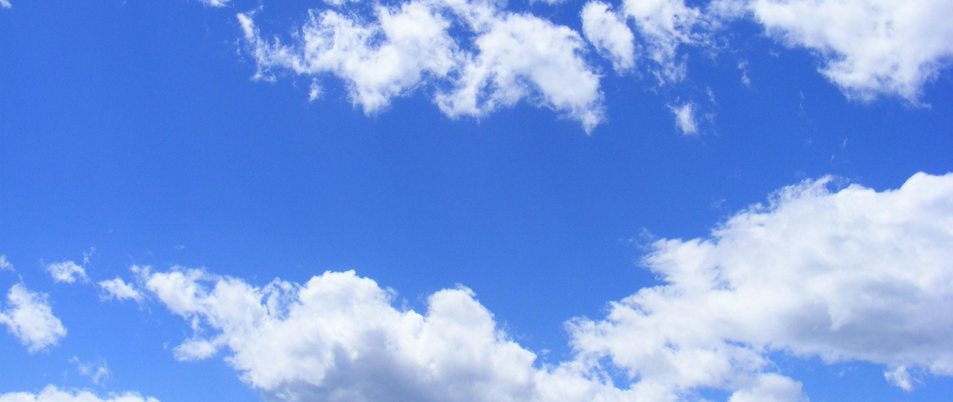 Clear blue sky with scattered white clouds, creating a bright and serene atmosphere.
