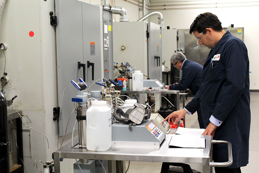 Lab technicians conducting tests in an industrial laboratory using specialized equipment.