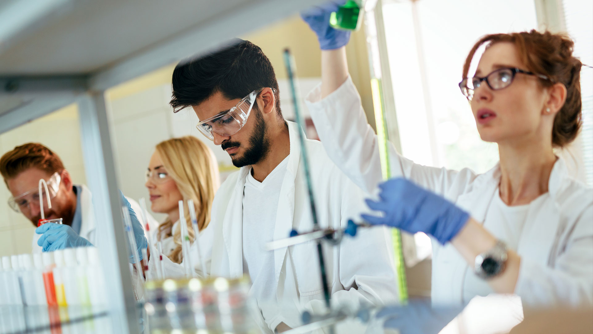 A group of scientists in a laboratory conducting experiments with test tubes and beakers.