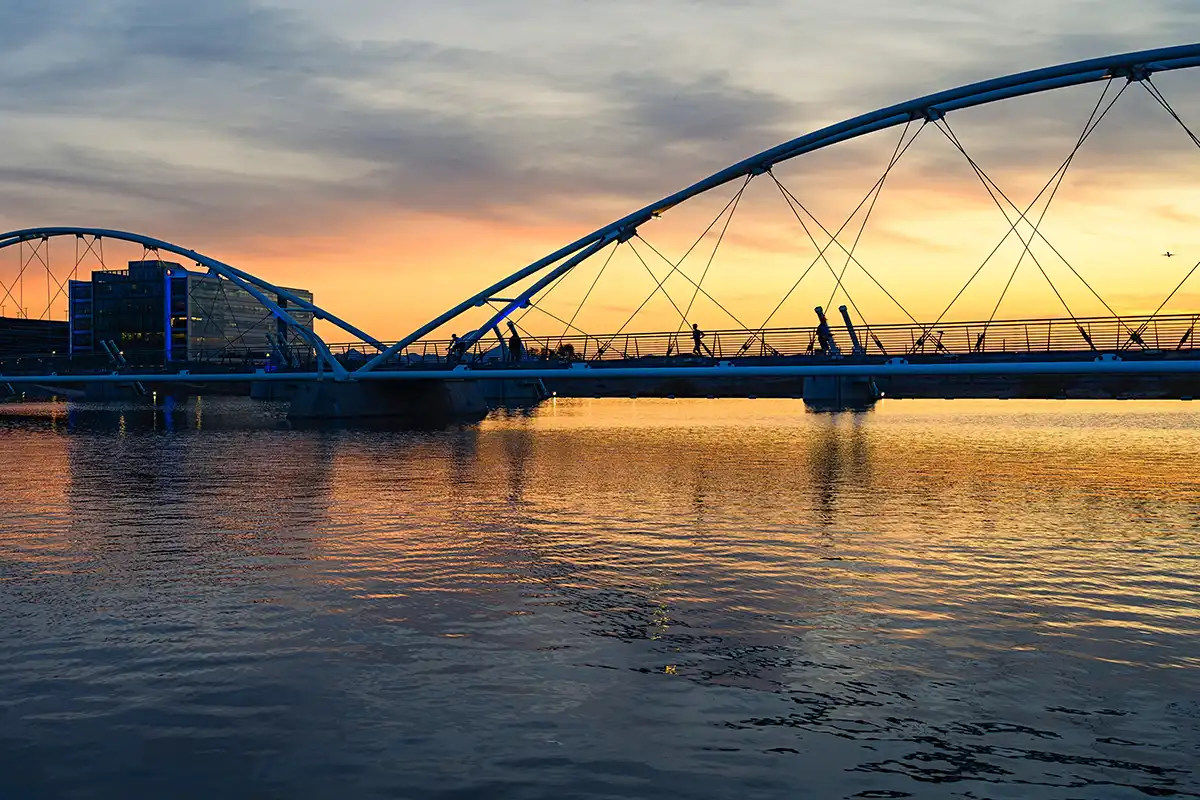 Pont piétonnier au coucher du soleil représentant l'impact communautaire et la connexion locale en Arizona