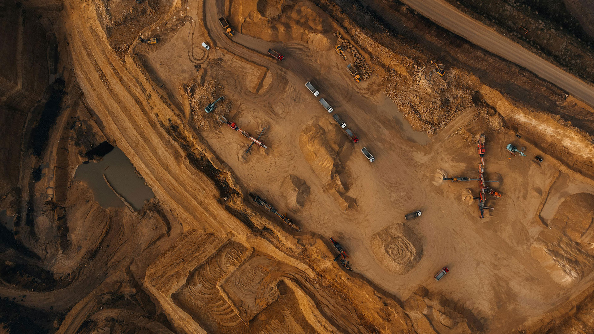 Un site de fouilles minières actif avec des véhicules industriels opérant dans la zone d'excavation.