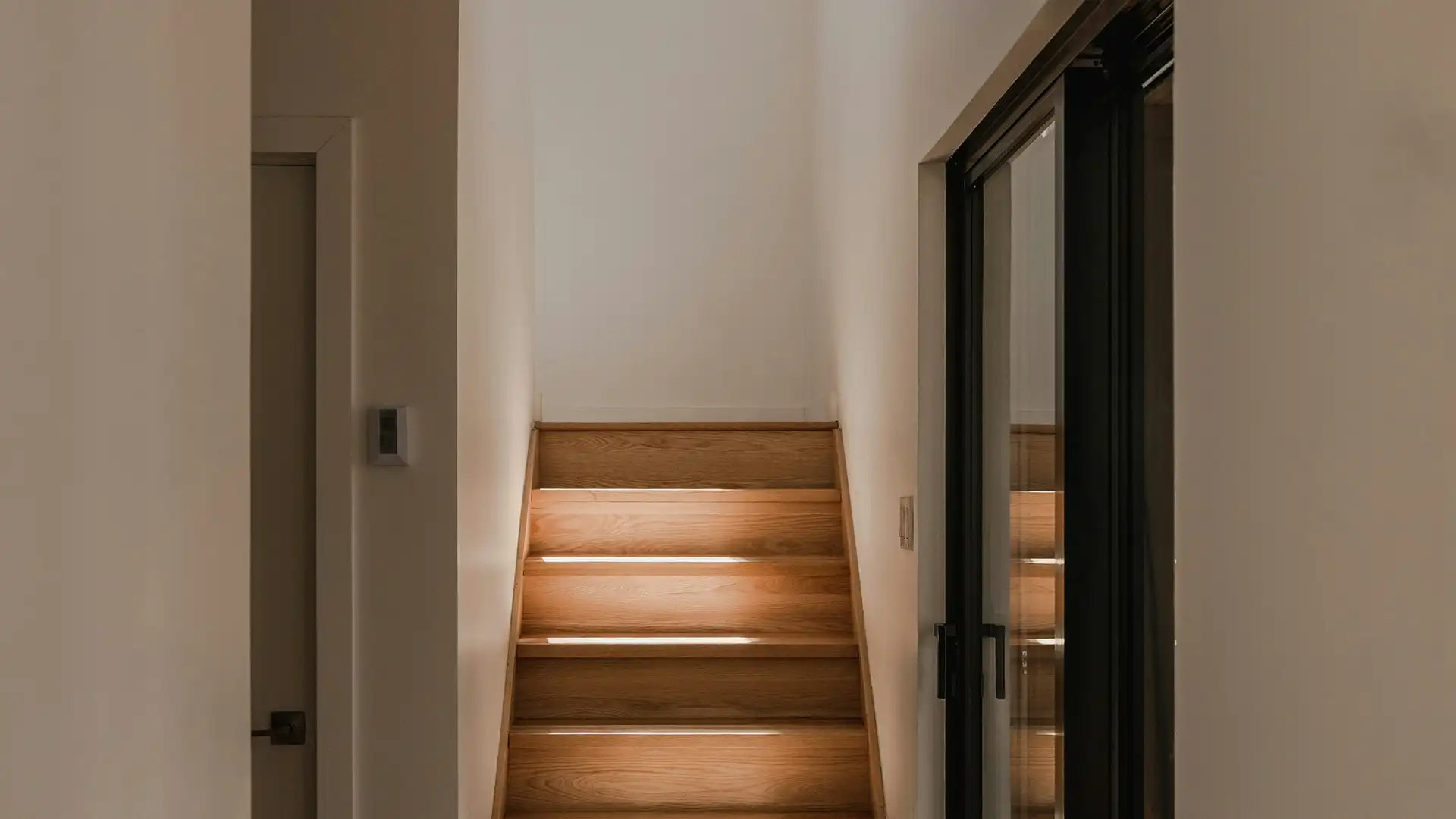 Interior stairs leading to a lower level, lit by natural light — symbolizing radon exposure in enclosed spaces